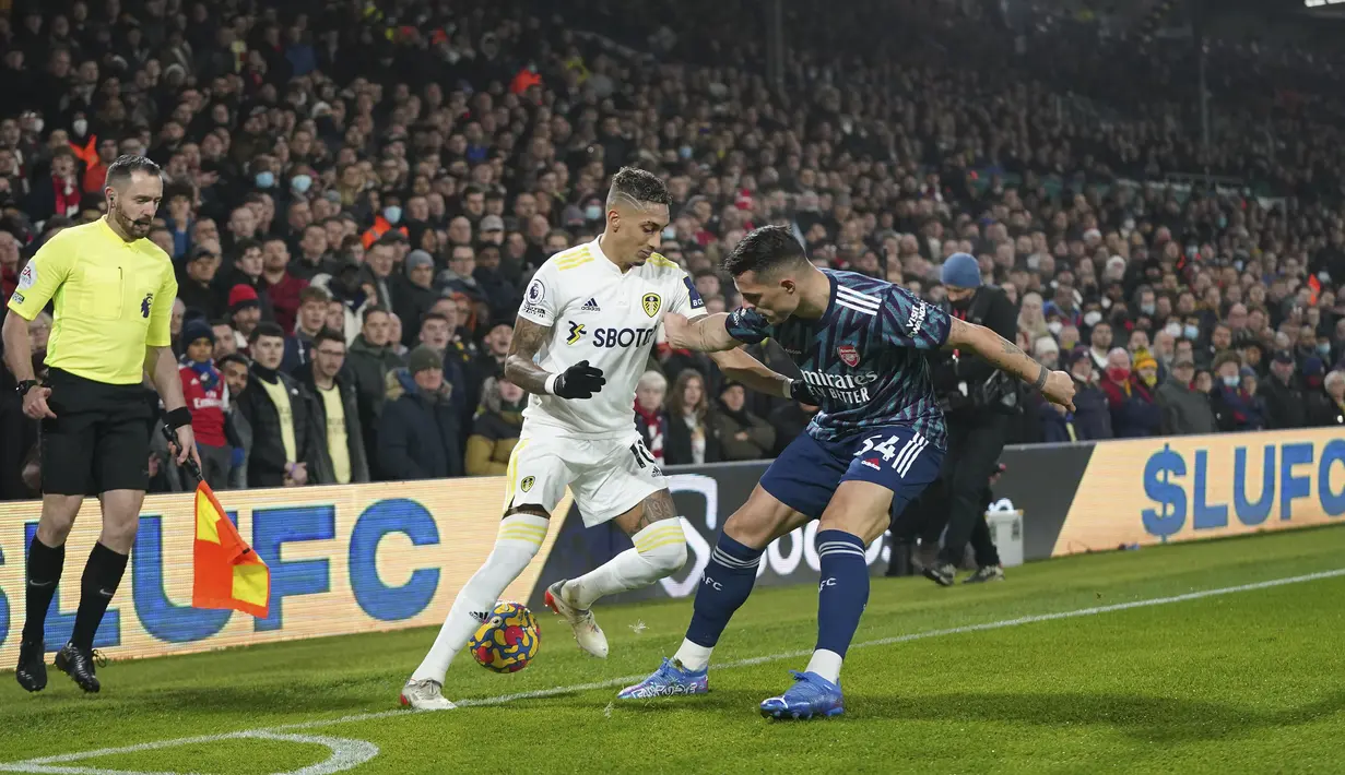 Gelandang Arsenal Granit Xhaka berebut bola dengan Penyerang Leeds United Raphinha pada pekan ke-18 Liga Inggris di Stadion Ellan Road, Leeds, Minggu (19/12/2021) dini hari WIB. Arsenal menang 4-1 di kandang Leeds United. (AP Photo/Jon Super)