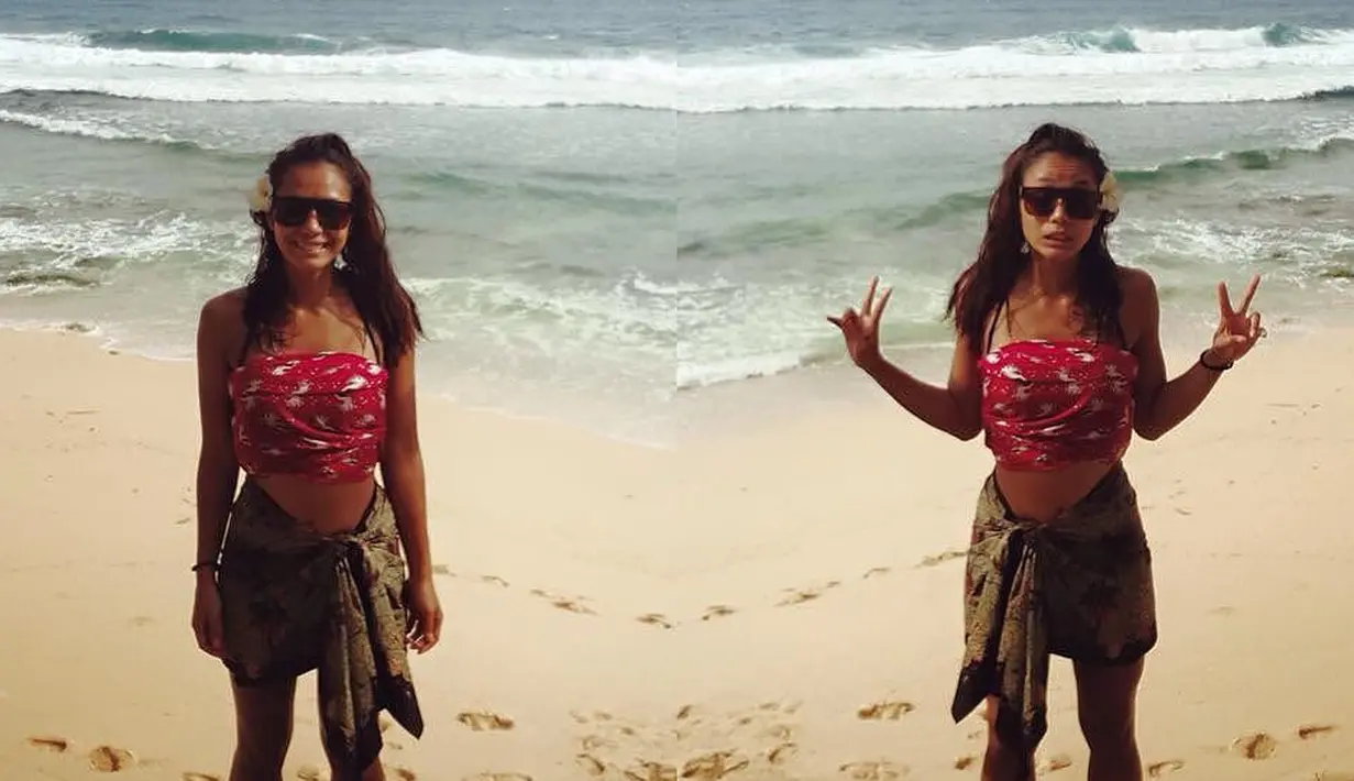 Saat di pantai, Adinia pun juga ternyaata memilih busana dengan nuansa etnik. Seperti yang ada di foto ini, untuk bagian bawah ia mengenakan yang berwarna cokelat dan kain berwarna pink dipilih untuk bagian dadanya. Unik banget kan? (Instagram/wrst)