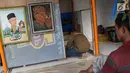 Seniman lukis memasang dinding lapak kios di Sentra Lukisan Pasar Baru, Jakarta, Jumat (16/11). Pemerintah Provinsi DKI Jakarta merevitalisasi 29 kios di Sentra Lukisan Pasar Baru. (Liputan6.com/Immanuel Antonius)