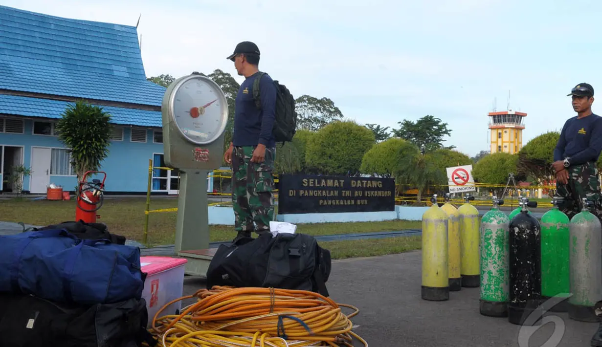 Penyelam dari TNI-AL menimbang berat badan sebelum memasuki helikopter yang akan memberangkatkan mereka menuju KRI Banda Aceh di Lanud Iskandar, Pangkalan Bun, Kalteng, Sabtu (10/1/2015).  (Liputan6.com/Andrian M Tunay)