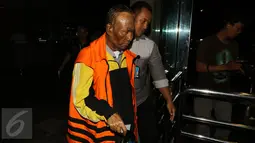 Sugiharto didampingi petugas berjalan keluar usai diperiksa KPK, Jakarta, Selasa (25/10). Tersangka korupsi paket penerapan pengadaan KTP elektronik atau e-KTP itu kini hanya menggunakan tongkat untuk membantunya berjalan. (Liputan6.com/Helmi Afandi)