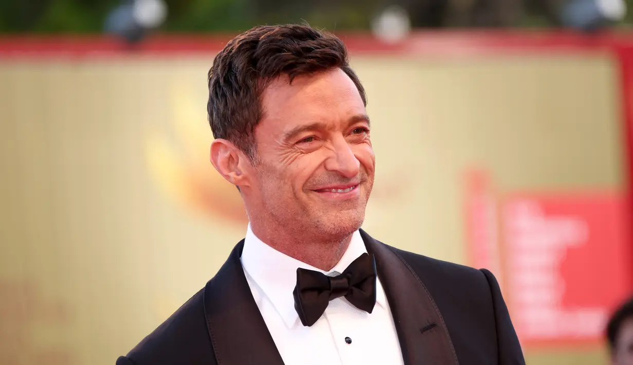 Hugh Jackman berpose untuk fotografer setibanya di pemutaran perdana film 'The Son' selama Festival Film Venesia edisi ke-79 di Venesia, Italia, Rabu (8/9/2022). Hugh Jackman terlihat mempesona menggunakan tuxedo hitam dengan dasi kupu-kupu. (Joel C Ryan/Invision/AP)