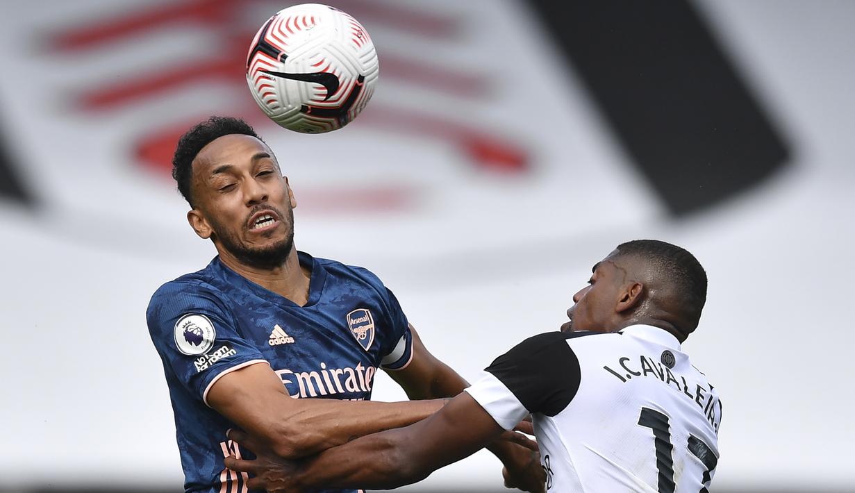 Penyerang Arsenal, Pierre-Emerick Aubameyang, berebut bola dengan penyerang Fulham, Ivan Cavaleiro, pada laga Liga Inggris di Craven Cottage, London, Sabtu (12/9/2020) malam WIB. Arsenal menang 3-0 atas Fulham. (Ben Stansall/Pool via AP)