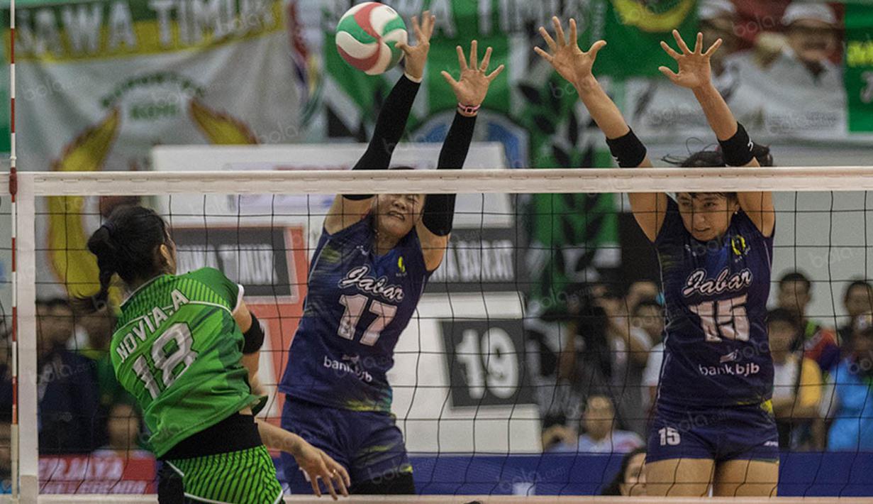 Pevoli Jawa Barat, Wilda Sri Nurfadilah dan Yolla Yuliana, berusaha menahan smash pevoli Jawa Timur, Novi Andriyanti. Jabar menang 3-0 atas Jatim. (Bola.com/Vitalis Yogi Trisna)