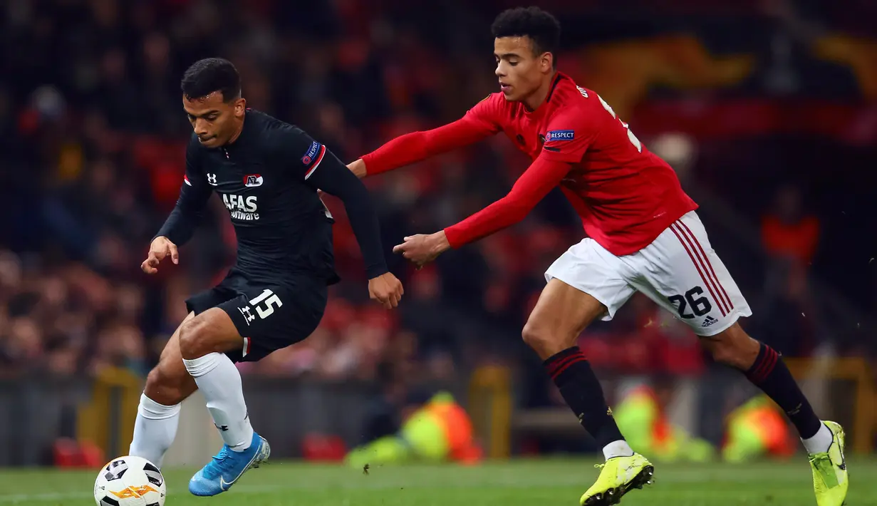 Pemain AZ Alkmaar Owen Wijndal (kiri) dan pemain Manchester United Mason Greenwood berebut bola saat pertandingan Grup L Liga Europa di Old Trafford, Manchester, Inggris, Kamis (12/12/2019). Manchester United menang 4-0. (AP Photo/Dave Thompson)
