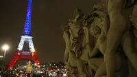 Gambar yang diambil Senin (16/11), memperlihatkan Menara Eiffel dihiasi lampu berwarna bendera Prancis merah, putih dan biru, untuk menghormati para korban serangan teror di Paris pada 13 November 2015 lalu. (AFP PHOTO/LUDOVIC MARIN)