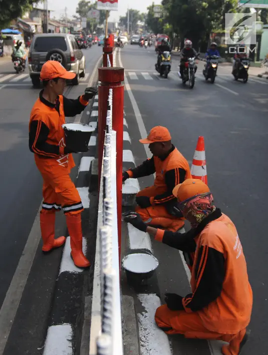 Petugas PPSU Kelurahan Kramat Jati melakukan pengecatan ulang pagar pembatas Jalan Raya Bogor, Jakarta, Selasa (17/7). Upaya penataan sekaligus mempercantik kawasan terus dilakukan jelang Asian Games dan Hari Kemerdekaan RI. (Liputan6.com/Arya Manggala)
