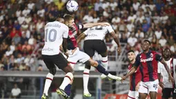 Pemain AC Milan, Rafael Leao, duel udara dengan pemain Bologna, Stefan Posch, pada pekan pertama Serie A di Stadion Renato Dall'Ara, Selasa (22/8/2023). AC Milan menang dua gol tanpa balas. (Massimo Paolone/LaPresse via AP)