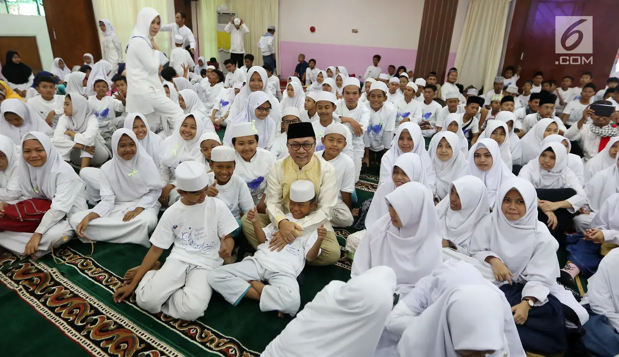Ketua MPR Zulkifli Hasan bercanda dengan anak-anak saat acara Tadarus dan Katham Al Quran bersama anak Yatim di Aula MAsjid Baiturahman Komplek MPR/DPR RI, Jakarta, Minggu (11/6). (Liputan6.com/JohanTallo)
