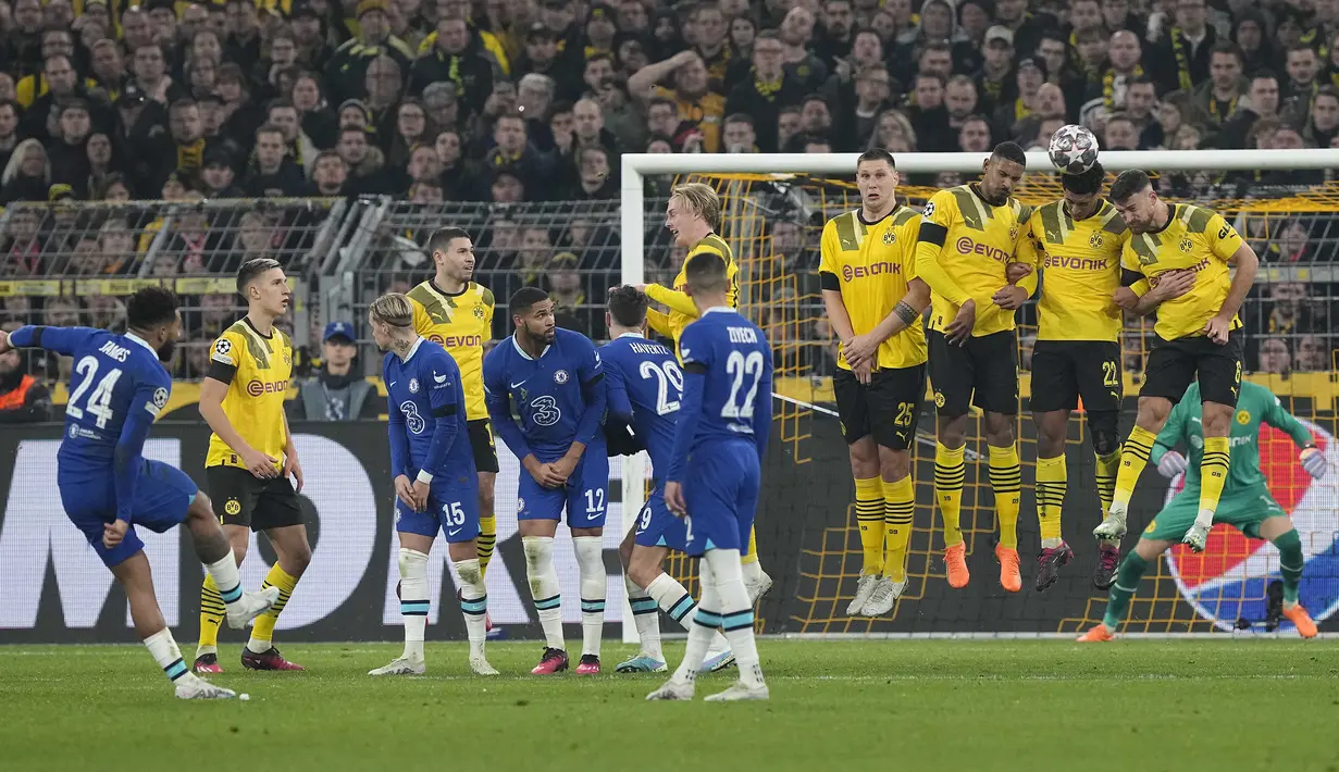 Pemain Chelsea, Reece James (kiri) melepaskan tendangan bebas yang berusaha diblok pagar hidup para pemain Borussia Dortmund dalam laga leg pertama babak 16 besar Liga Champions 2022/2023 di Signal Iduna Park, Dortmund, Kamis (16/2/2023) dini hari WIB. (AP Photo/Martin Meissner)