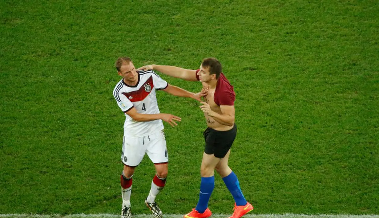 Benedikt Hoewedes mencoba mengelak dari serangan fans nakal tersebut, Brasil, Senin (14/07/2014) (AFP PHOTO/FABRIZIO BENSCH)