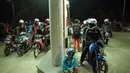 Di SPBU kawasan Karawang, antrean kendaraan roda dua yang cukup panjang mengakibatkan petugas pom bensin melayani tiga jalur pengisian BBM, Jumat (25/7/14). (Liputan6.com/Miftahul Hayat)