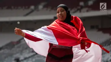 Pelari Indonesia, Tiarani Karisma Evi melakukan selebrasi usai meraih medali emas Asian Para Games cabang atletik nomor lari 100 meter T42 / T63 di SUGBK, Jakarta, Rabu (10/10). Evi mencatatkan waktu 14,98 detik. (Bola.com/Vitalis Yogi Trisna)