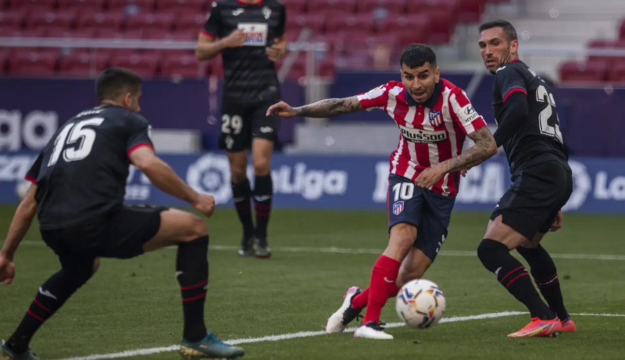 Striker Atletico Madrid, Angel Correa (kedua dari kanan) melewati bek Eibar untuk mencetak gol kedua timnya ke gawang Eibar dalam laga lanjutan Liga Spanyol 2020/2021 pekan ke-31 di Wanda Metropolitano Stadium, Madrid, Minggu (18/4/2021). Atletico menang 5-0 atas Eibar. (AP/Bernat Armangue)