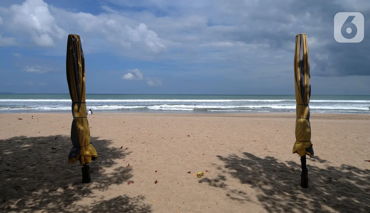 Tenda-tenda yang ditutup di kawasan Pantai Kuta, Bali, Jumat (3/9/2021). Sepinya wisatawan yang datang ke Pulau Bali selama PPKM Darurat yakni hanya sebesar rata-rata 500 wisatawan lokal menyebabkan sejumlah tempat wisata pantai sepi pengunjung. (merdeka.com/Arie Basuki)