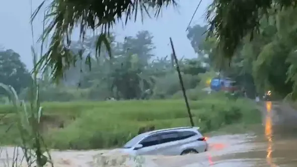 <p>Mobil terseret arus banjir di Kampung Nawit, Cisaat, Setu, Bekasi, Jawa Barat, Selasa (4/3/2025). (Tangkapan layar)</p>