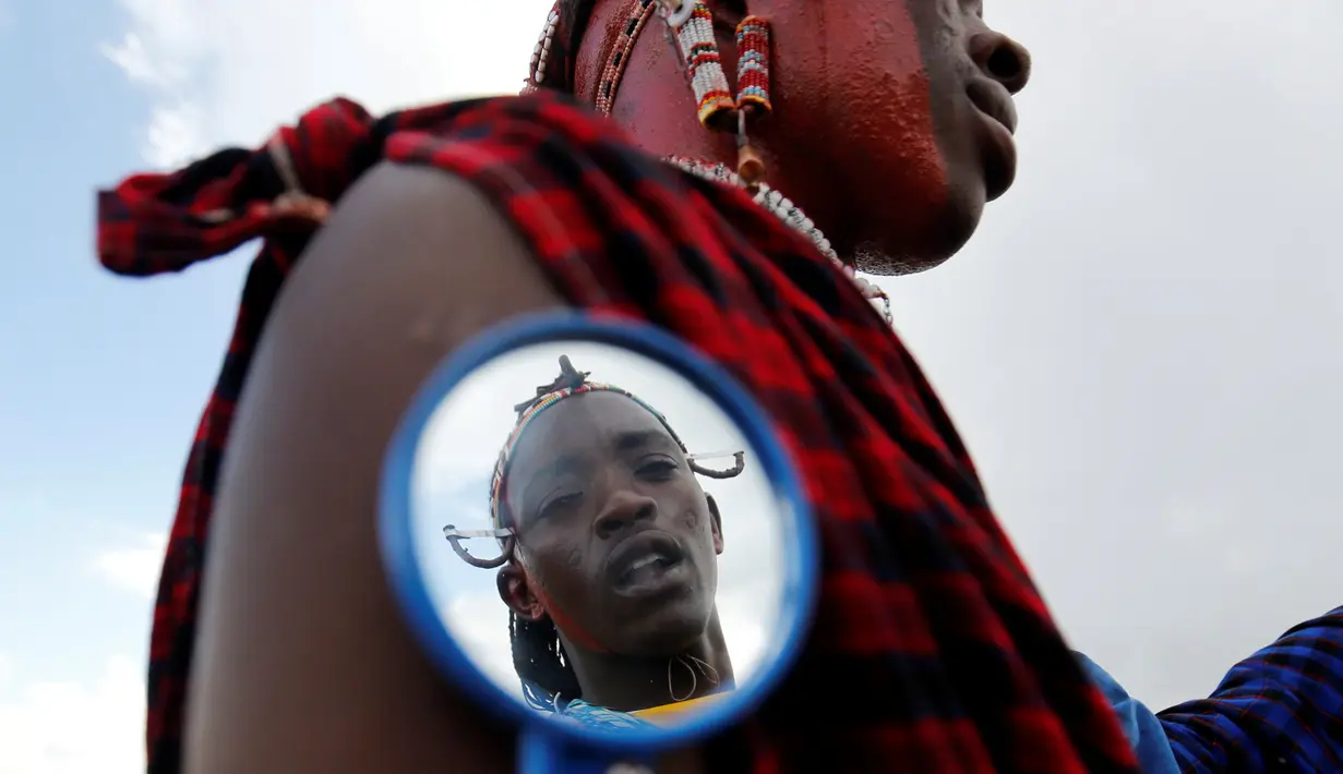 Seorang suku Maasai berias saat persiapan Olimpiade Masai 2016 di cagar alam Sidai Oleng, kaki Gunung Kilimanjaro dekat perbatasan Kenya-Tanzania (10/12). (Reuters/Thomas Mukoya)