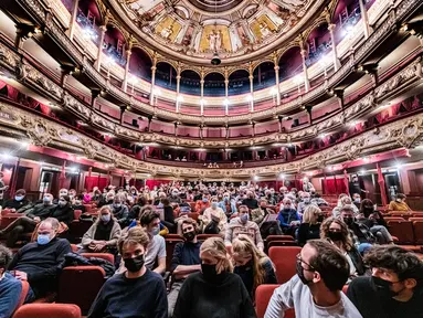 Penonton mengenakan masker menunggu dimulainya pementasan 'The Sheep Song' oleh FC Bergman, di teater Bourlaschouwburg di Antwerpen, Belgia, Rabu (29/12/2021). Dewan Negara membatalkan keputusan untuk menutup bioskop sebagai bagian dari aturan pembatasan Covid-19. (JONAS ROOSENS/BELGA/AFP)
