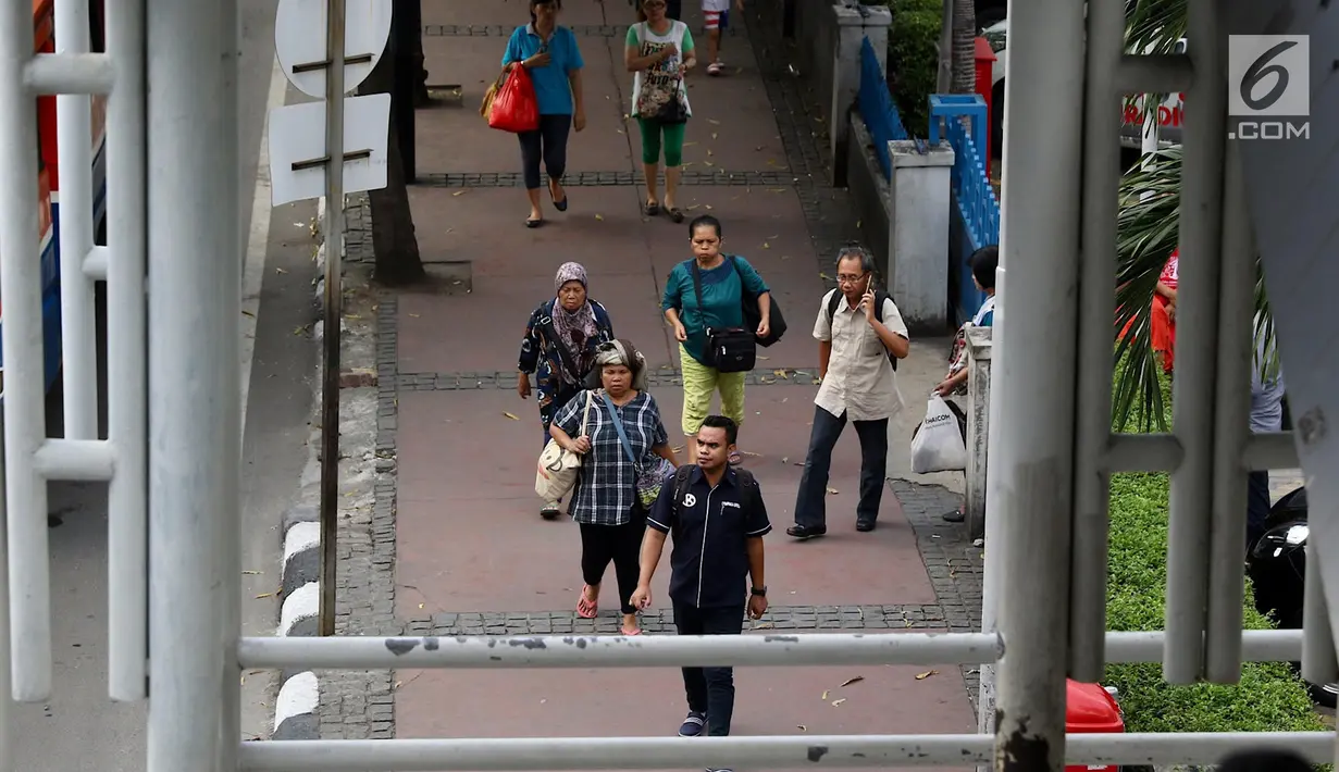 Pejalan kaki melintasi trotoar di kawasan MH Thamrin, Jakarta, Selasa (6/3). Sebagai bagian penataan jalan dan trotoar, Pemprov DKI menegaskan akan menyapu bersih PKL di sepanjang kawasan Sudirman – MH Thamrin. (Liputan6.com/Immanuel Antonius)