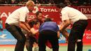 Ratchanok Intanon, dibawa keluar lapangan setelah mengalami cedera kaki kanan saat bertanding melawan pebulutangkis Indonesia, Lindaweni Fanetri. (Bola.com/Arief Bagus)