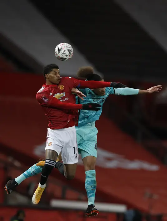 Striker Manchester United, Marcus Rashford (kiri) bersaing berebut bola dengan bek Liverpool, Rhys Williams (kanan) dalam laga putaran keempat Piala FA di Stadion Old Trafford, Senin dinihari WIB (25/1/2021). Manchester United atau MU singkirkan Liverpool usai menang 3-2. (PHIL NOBLE/POOL/AFP)