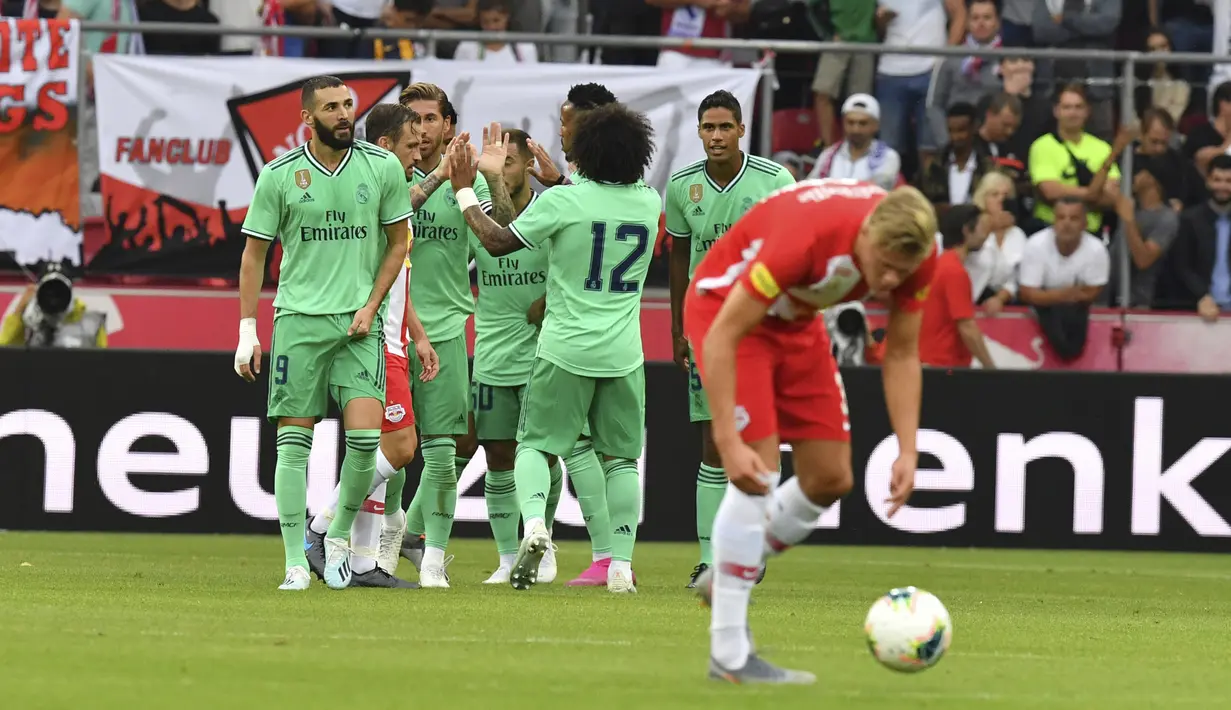 Gelandang Real Madrid, Eden Hazard (tengah) berselebrasi dengan rekan-rekannya usai mencetak gol ke gawang Red Bull Salzburg pada laga persahabatan di Red Bull Arena, Austria (8/8/2019). Winger asal Belgia itu mencetak gol perdananya untuk klub barunya Real Madrid. (AP Photo/Kerstin Joensson)