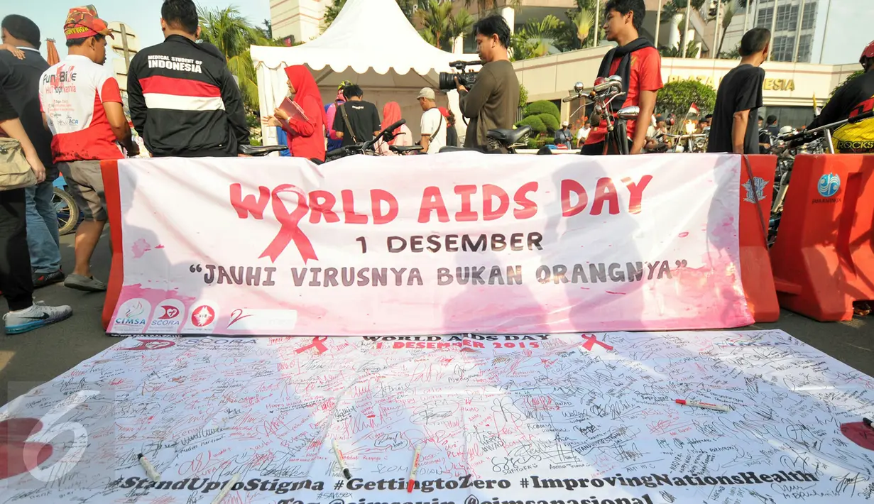 Sebuah spanduk petisi Peduli HIV/AIDS dibentangkan di kawasan Bundaran HI saat Car Free Day, Jakarta, Minggu (13/12/2015). Kegiatan tersebut dalam rangka memperingati hari AIDS sedunia. (Liputan6.com/Yoppy Renato)