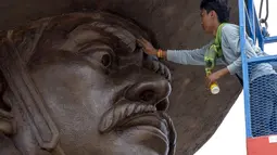 Pekerja membersihkan wajah patung Raja Taksin di Taman Ratchapakdi, Hua Hin, Thailand, Rabu  (5/8/2015). Taman dibangun untuk menghormati raja Thailand masa lalu dan para prajurit yang terletak di dekat Klai Kangwon Palace. (REUTERS/Athit Perawongmetha)