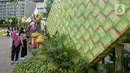 <p>Sejumlah warga memperhatikan dekorasi bertemakan Idul Fitri di kawasan Bundaran HI, Jakarta, Rabu (27/4/2022). Dekorasi berbentuk masjid, ketupat, dan bedug yang dihiasi oleh tanaman tersebut dalam rangka menyambut Idul Fitri 1443 Hijriah. (Liputan6.com/Faizal Fanani)</p>