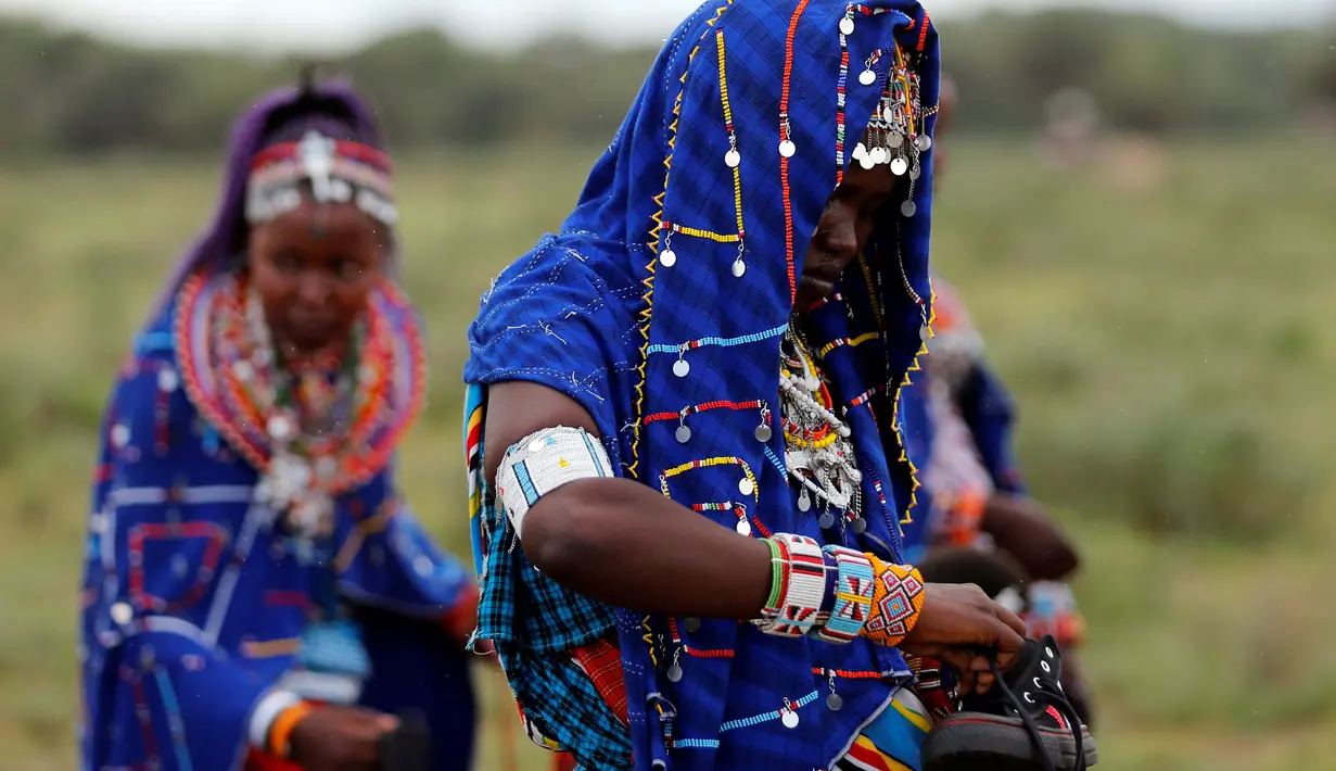 Seorang wanita dari suku Maasai menyiapkan sepatu untuk mengikuti Olimpiade Masai 2016 di cagar alam Sidai Oleng, kaki Gunung Kilimanjaro dekat perbatasan Kenya-Tanzania (10/12). (Reuters/Thomas Mukoya)