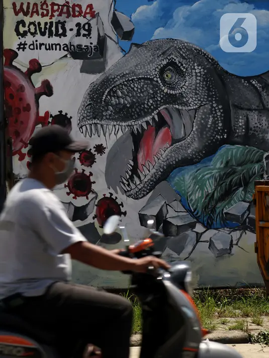 Pengendara motor melintas di depan mural bertema waspada COVID-19 di Jalan Baru, Depok, Jawa Barat, Selasa (7/4/2020). Sejumlah pesan disampaikan dengan beragam cara untuk mengingatkan masyarakat agar ikut serta dalam upaya memutus mata rantai penyebaran COVID-19. (Liputan6.com/Helmi Fithriansyah)