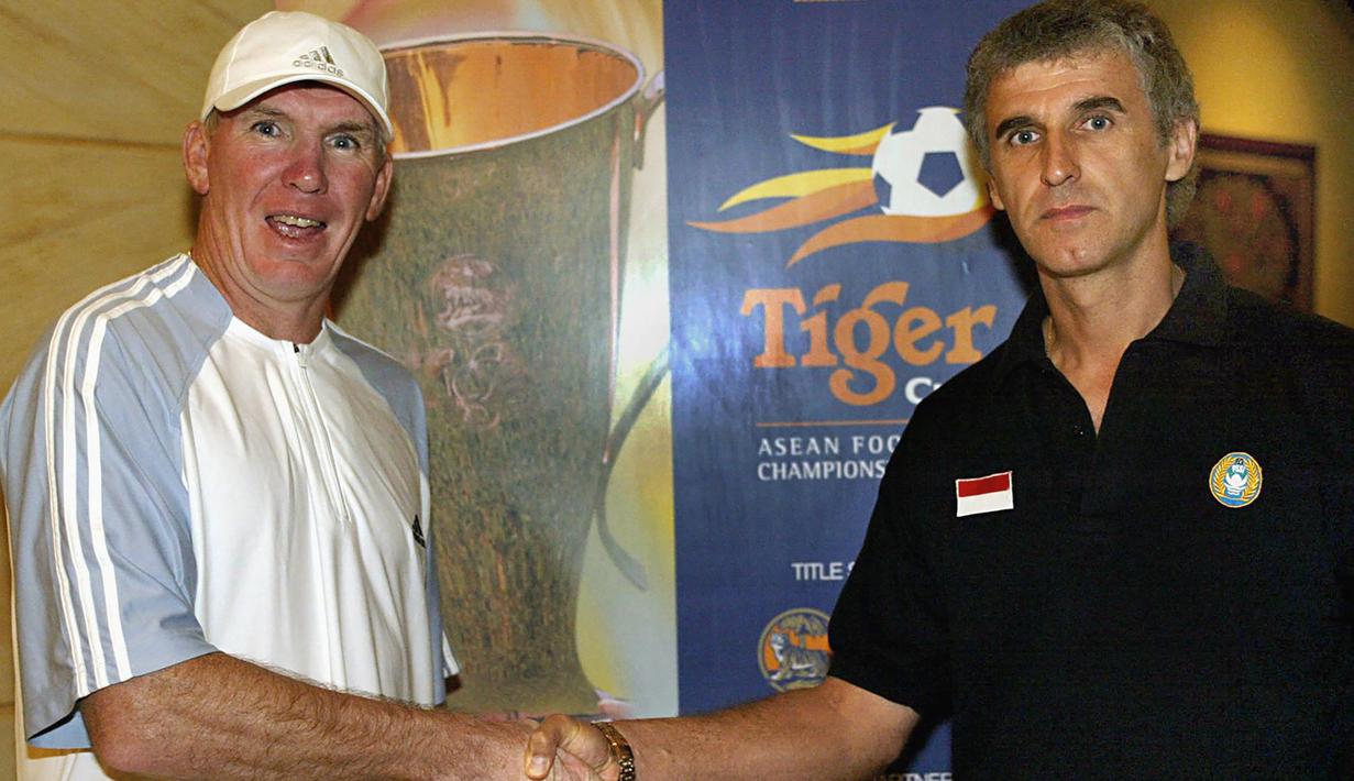 Peter Withe (kiri). Pelatih asal Inggris berusia 71 tahun yang sejak Mei 2018 resmi menjadi pemilik klub Deffo FC yang berlaga di kasta ketiga Liga Thailand ini total mengoleksi 2 gelar Piala AFF sepanjang sejarah. Kedua trofi tersebut diraihnya bersama Timnas Thailand pada Piala AFF edisi 2000 dan 2002. Peter Withe sendiri secara keseluruhan membesut Timnas Thailand selama 5 tahun mulai Juli 1998 hingga Desember 2003. Selain 2 gelar Piala AFF, ia juga berjasa membawa Timnas Thailand merebut medali emas pada ajang SEA Games 1999. (AFP/World Sport Group/Stanley Chou)