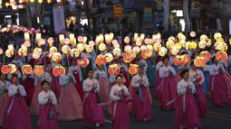 Sejumlah wanita membawa lampion saat Lotus Lantern Festival di Seoul, Korea Selatan, Sabtu (29/4). Parade ini bagian dari jelang perayaan ulang tahun Buddha yang jatuh pada 3 Mei 2017. (AP Photo / Lee Jin-man)