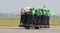 Anggota Tornado dari Army Service Corps (ASC) berada di satu motor 500 cc di Bangalore, India (19/11). Tim Tornado menciptakan rekor dunia baru setelah 58 orang naik satu motor 500 cc dan mengendarainya sejauh 1200 meter. (AFP Photo/Manjunath Kiran)