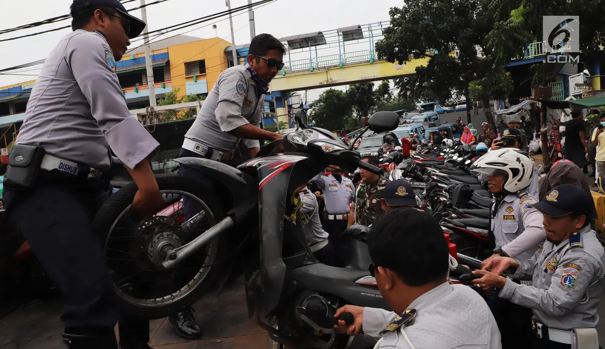 Petugas Dishub DKI mengangkut sepeda motor saat operasi penertiban di Pasar Tanah Abang, Jakarta, Senin (21/5). Banyak preman yang memanfaatkan momen meningkatnya pengunjung pasar Tanah Abang dengan membuka area parkir liar. (Liputan6.com/Arya Manggala)