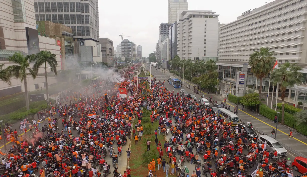 Foto udara suporter Persija Jakarta, The Jakmania, tumpah ruah saat konvoi merayakan gelar Piala Liga 1 musim 2018 di Bundaran HI, Jakarta, Sabtu (15/12). Persija berhasil juara Liga 1 usai mengalahkan Mitra Kukar. (Bola.com/Muhammad Husni)