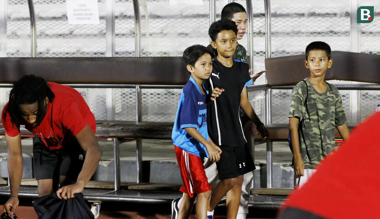 Fans cilik mencari pemain pemain Timnas Indonesia U-19 yang akan diajak berfoto usai melakukan latihan jelang Piala AFF U-19 2022 di Stadion Madya, Jakarta, Selasa (21/6/2022). (Bola.com/M Iqbal Ichsan)