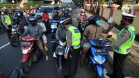 Petugas memeriksa identitas pengendara dalam rangka Pemberlakuan Pembatasan Kegiatan Masyarakat (PPKM) Darurat di pos penyekatan Pasar Jumat, Jakarta, Sabtu (3/7/2021). Polda Metro Jaya menyiapkan 63 titik penyekatan selama penerapan PPKM Darurat di Jakarta dan sekitarnya. (merdeka.com/Arie Basuki)