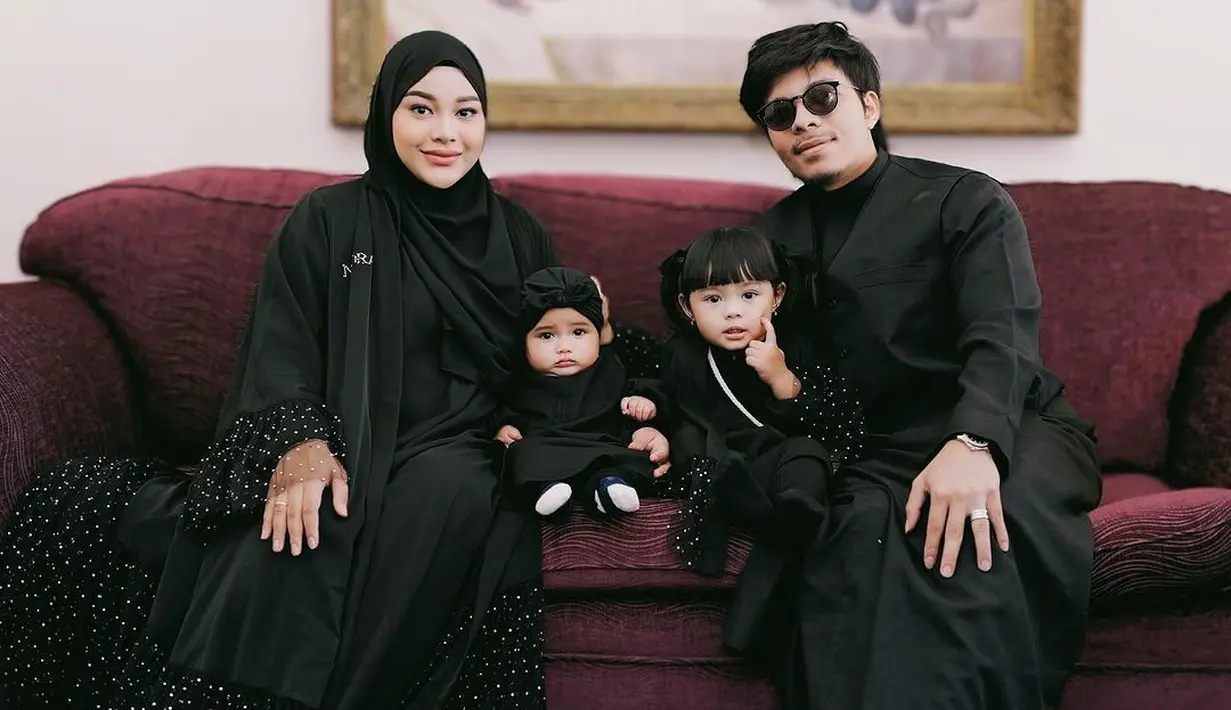 Aurel Hermansyah juga memilih baju Lebaran bernuansa gelap. Gamis hitam dnegan detail payet silver yang membuat penampilan Aurel lebih menonjol, dipadukan dengan hijab hitam polos. [Foto: Instagram/attahalilintar]