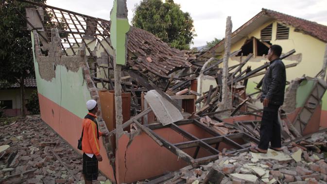 Penduduk desa memeriksa rumah mereka yang rusak setelah gempa magnitudo 5,1  di Sukabumi, Jawa Barat (10/3/2020). Pusat gempa tepatnya berlokasi di darat pada jarak 23 kilometer arah Timur Laut Kota Pelabuhan Ratu, Kabupaten Sukabumi, Jawa Barat pada kedalaman 10 kilometer. (AFP/Wulung Widarba)