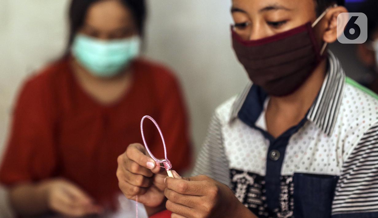 Anak-anak membuat serokan ikan cupang di rumah kontrakan Udin, Sukabumi Selatan, Jakarta Barat, Selasa (22/12/2020). Musim ikan cupang saat ini dimanfaatkan oleh Udin untuk membuat dan menjual serokan ikan seharga Rp 4.000. (Liputan6.com/Johan Tallo)