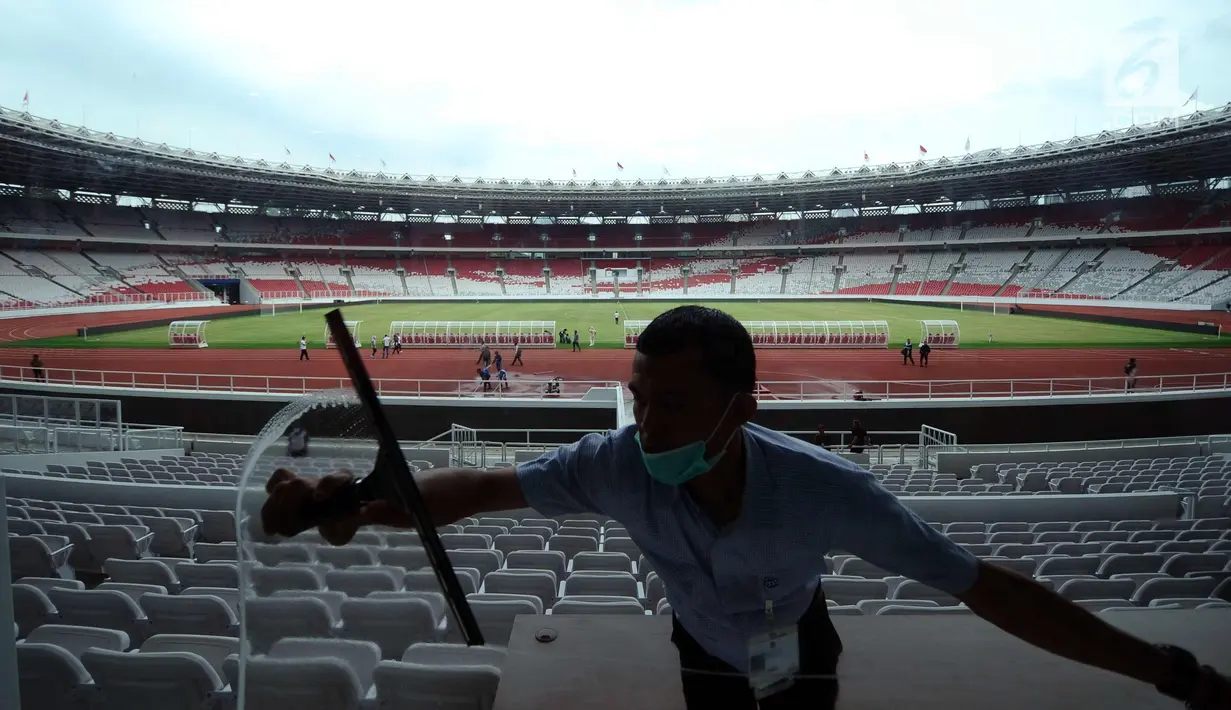 Pekerja membersihkan kaca tribun VIP di Stadion Gelora Bung Karno, Jakarta, Jumat (12/1). Rencananya, Stadion GBK akan diresmikan penggunaannya pasca renovasi oleh Presiden Joko Widodo, Minggu (14/1). (Liputan6.com/Helmi Fithriansyah)