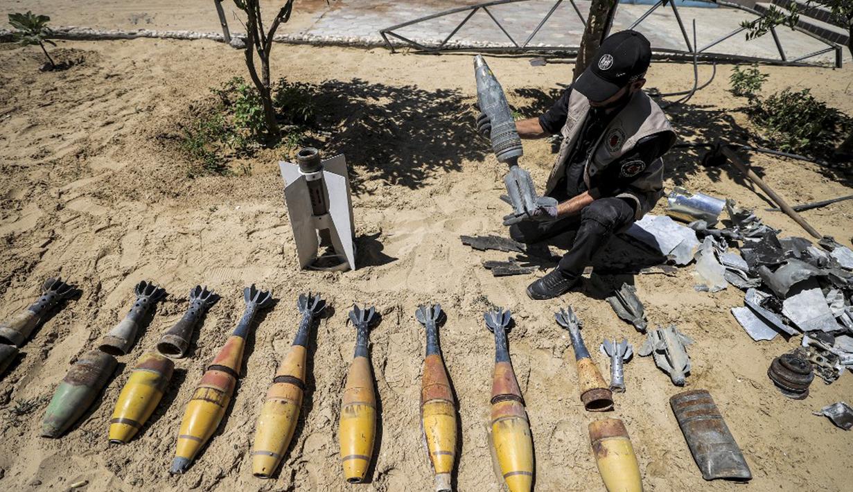 Seorang ahli bahan peledak Hamas menunjukkan proyektil yang tidak meledak setelah konflik Mei 2021 dengan Israel di kantor polisi setempat di Khan Yunis, Jalur Gaza, Sabtu (5/6/2021). Perang 11 hari antara Hamas dan Israel menewaskan 254 orang Palestina dan 12 orang Israel. (MAHMUD HAMS/AFP)