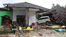 Sebuah mobil di antara puing-puing dari rumah yang rusak setelah tsunami menerjang kawasan Anyer, Banten, Minggu (23/12). Data sementara jumlah korban dari bencana tsunami di Selat Sunda tercatat 168 orang meninggal dunia. (Liputan6.com/Angga Yuniar)