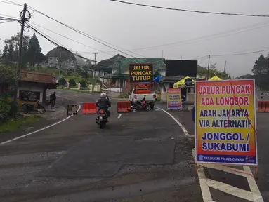 Papan penutupan arus lalu lintas terpasang di jalan Cimacan, Kabupaten Cianjur, Jawa Barat, Rabu (14/2). Setelah ditutup sejak 5 Februari lalu karena longsor, kawasan puncak Bogor sampai Cianjur menjadi seperti kota mati. (Liputan6.com/Achmad Sudarno)