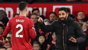 Pelatih kepala Manchester United asal Portugal, Ruben Amorim (kanan), berbicara dengan bek Manchester United asal Portugal bernomor punggung 02, Diogo Dalot (kiri), selama pertandingan Liga Inggris antara Manchester United dan Bournemouth di Old Trafford, Manchester, barat laut Inggris, Sabtu (27-12-2025) dini hari WIB. (PETER POWELL/AFP)