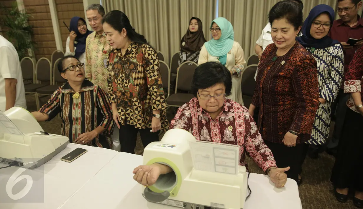 Menteri Lingkungan Hidup dan Kehutanan Siti Nurbaya dan Menteri Pemberdayaan dan Perlidungan Anak Yohana Yembise mencoba langsung alat pengukur tekanan darah mandiri di kantor Kemenko PMK Jakarta, Rabu (22/2). (Liputan6.com/Faizal Fanani)