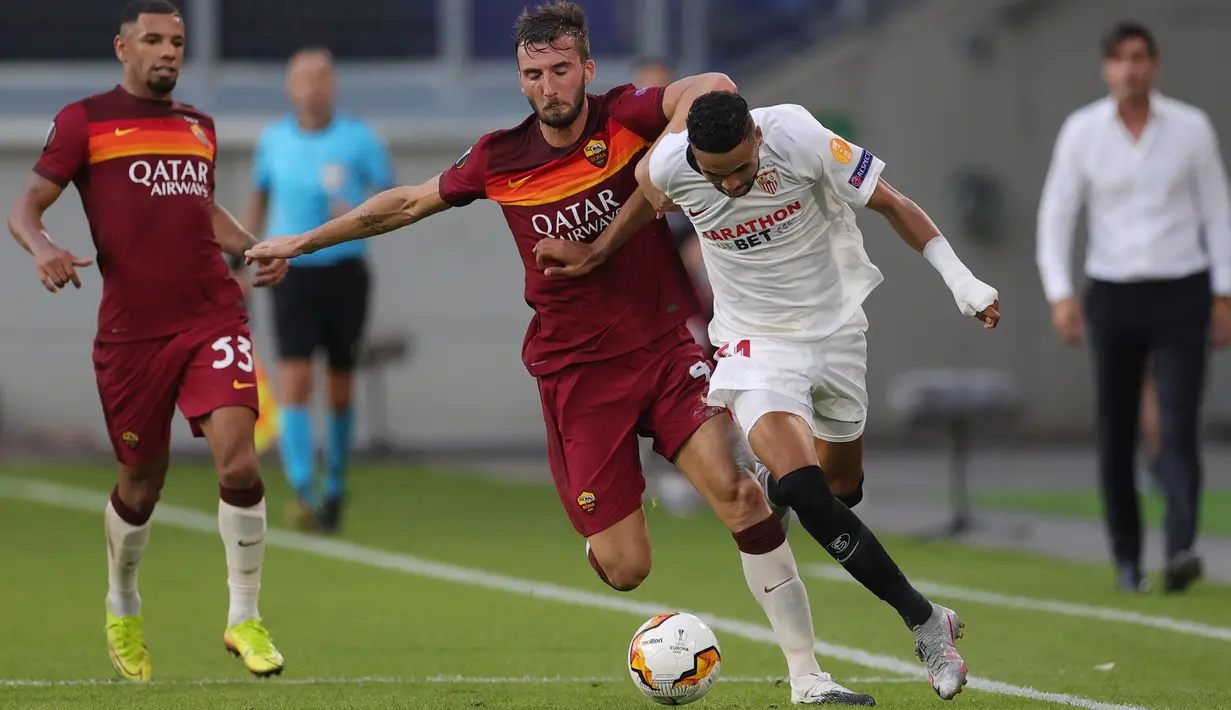 Penyerang Sevilla, Youssef En-Nesyri, berebut bola dengan gelandang AS Roma, Bryan Cristante, dalam laga babak 16 besar Liga Europa 2019/2020 di MSV-Arena, Jerman, Jumat (7/8/2020) dini hari WIB. Sevilla menang 2-0 atas AS Roma. (AFP/Friedemann Vogel/pool)