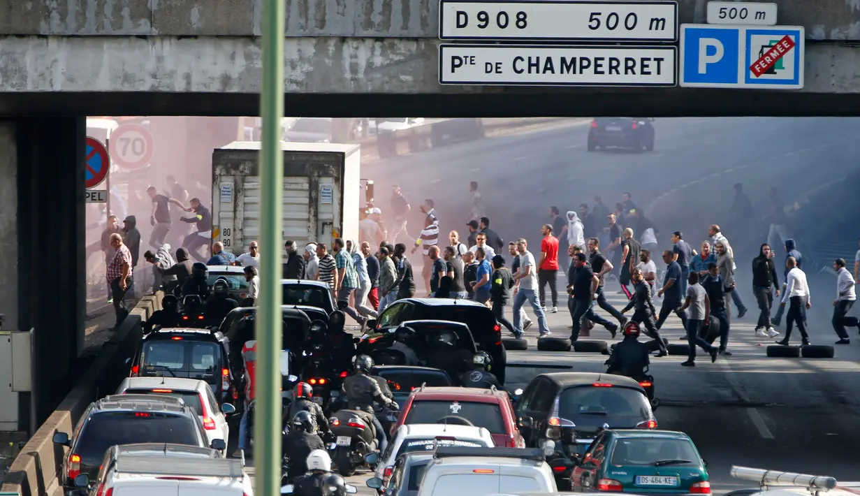 Sejumlah Sopir taksi Perancis, berjalan memblokir lalu lintas di jalan lingkar Paris selama protes terhadap mobil mobil layanan Uber, Perancis, Kamis (25/6/2015). Para supir memprotes layanan Online taksi Uber. (REUTERS/Charles Platiau)
