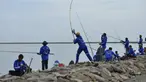 Peserta saat mengambil bagian dalam kompetisi memancing di pantai Banda Aceh (24/11/2019). Sebanyak 1.024 pemancing ikut memeriahkan Banda Aceh Fishing Tournament 2019. (AFP Photo/Chaideer Mahyuddin)
